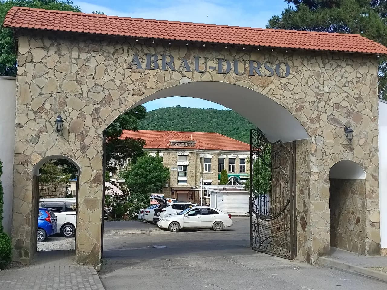 Каменная арка входа в имение Абрау-Дюрсо с красной черепичной крышей